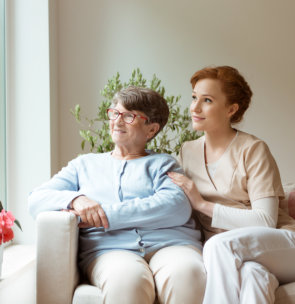 caregiver with elder woman looking out the window