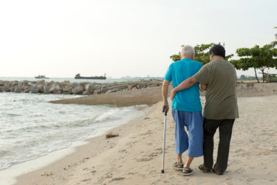 man helping senior walk