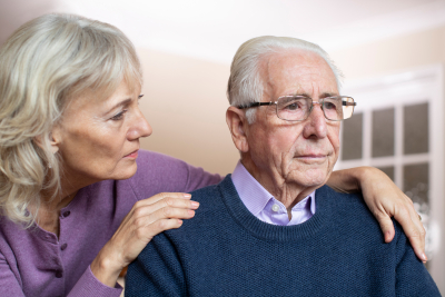 Confused Senior Man Suffering With Dementia Being Comforted By Wife