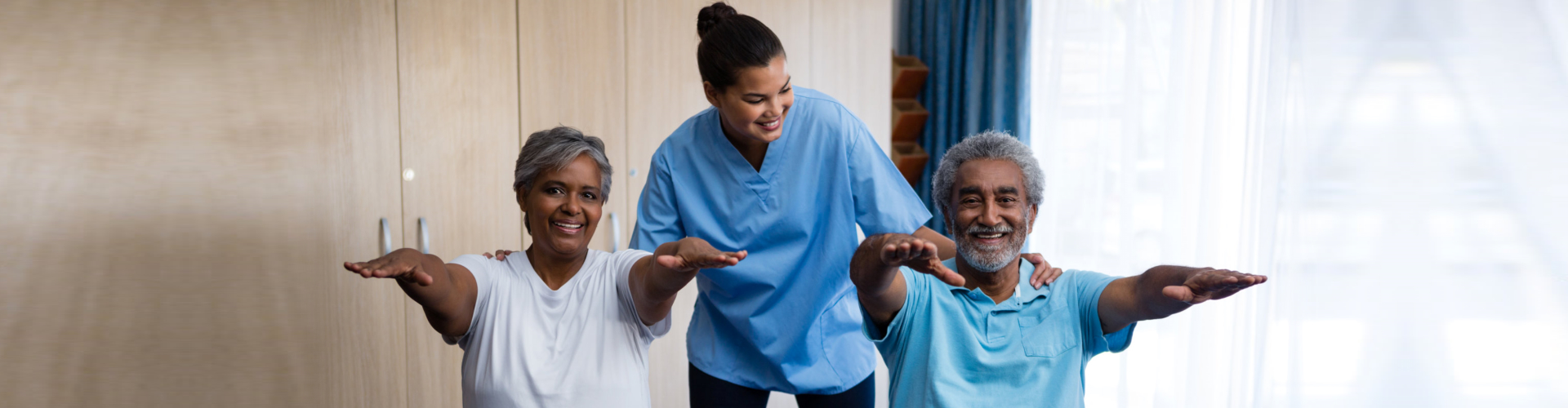 two seniors exercise with caregiver